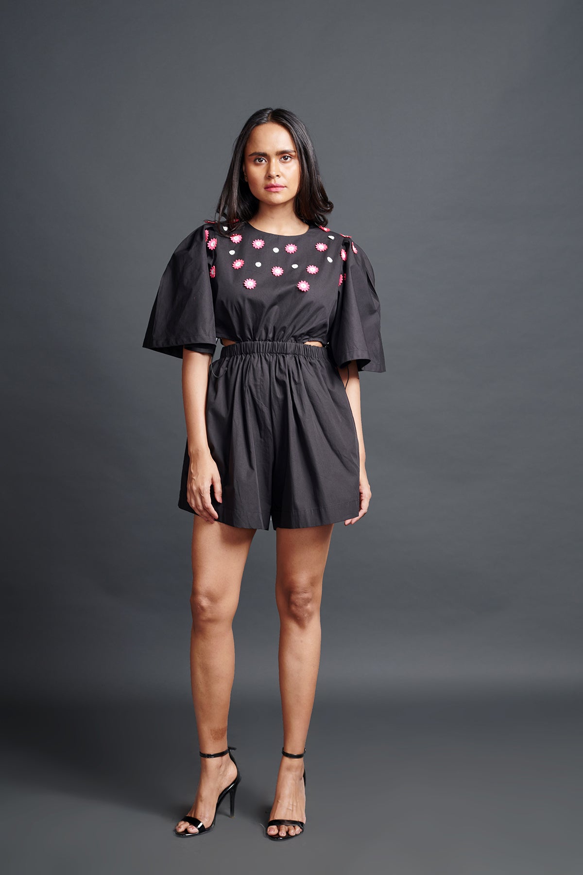 Image of BLACK PLAYSUIT IN COTTON BASE WITH CUTWORK EMBROIDERY AND BACKLESS SIDE CUT-OUT DETAIL. From savoirfashions.com