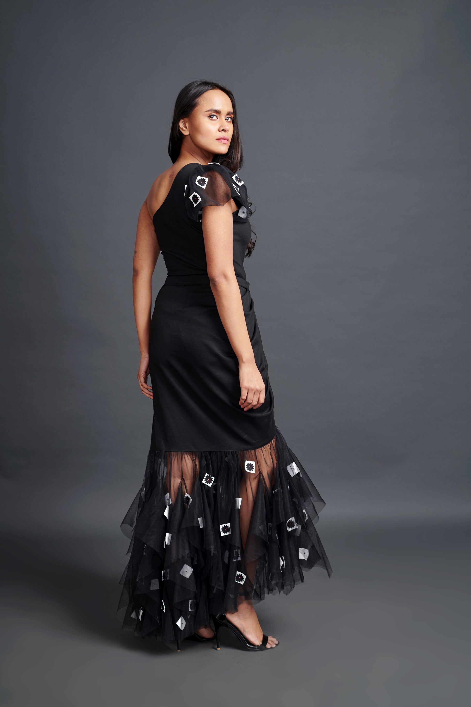 Image of BLACK ONE SHOULDER BODY SUIT WITH CONFETTI DETAILING ON A HIGH-LOW LONG SKIRT. From savoirfashions.com