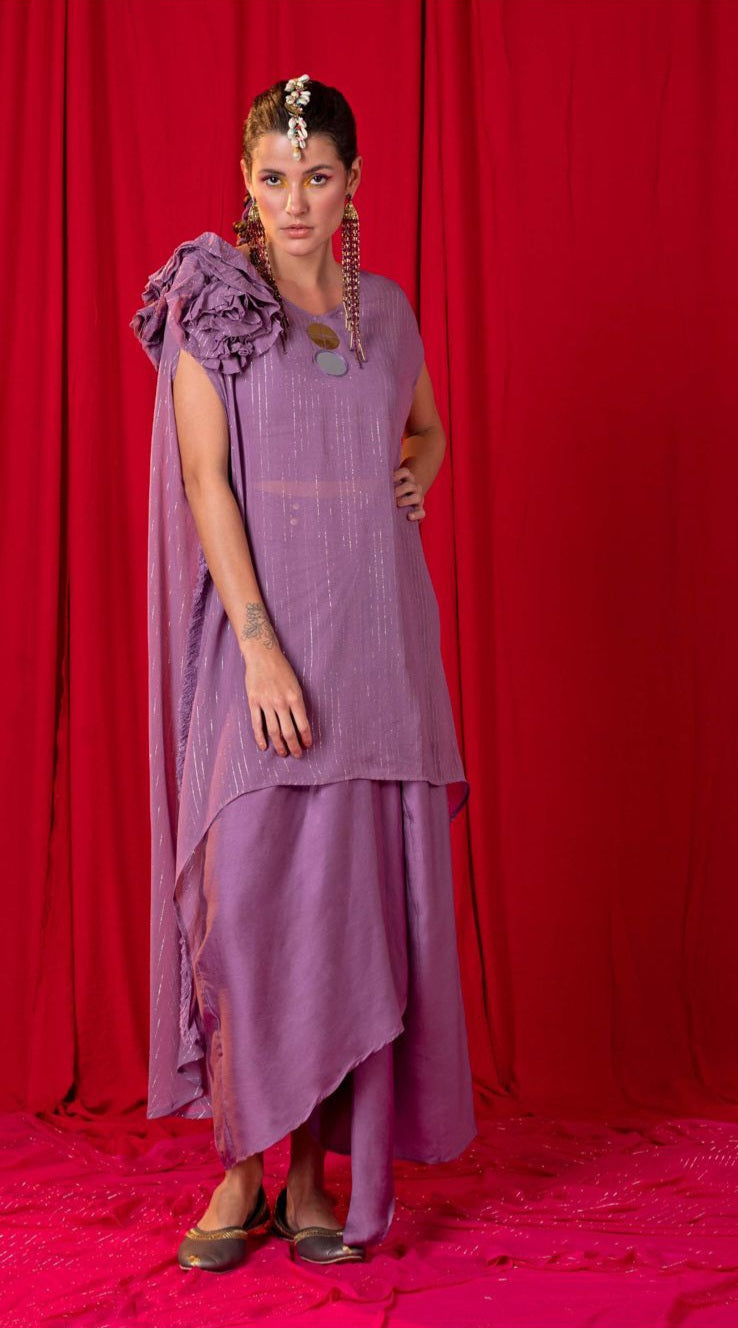 Image of This lavender two-piece twin set has an asymmetric kimono design featuring a dramatic frill and two metal coins, paired with a draped skirt. Make a statement in style with this chic and sophisticated outfit.  From savoirfashions.com