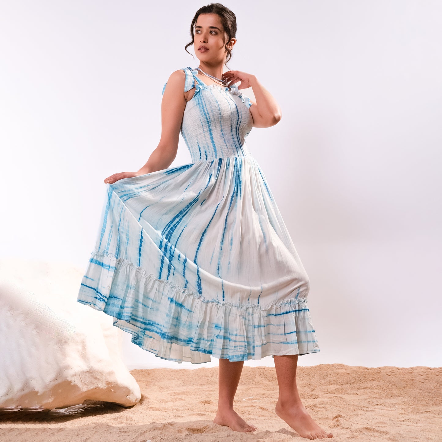 Image of This Blue Tie-Dye Smocking Long Dress combines a timeless silhouette with current trends. Crafted from a lightweight fabric, this dress features a smocked bodice, a v-neckline, and a graceful long skirt. Perfect for summer occasions, this dress is sure to make heads turn.  From savoirfashions.com