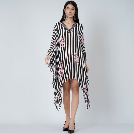 Image of This BLACK AND WHITE EMBELLISHED FLORAL FRILL KAFTAN features sophisticated white floral embroidery on 100% polyester fabric, combining style and comfort. Its elegant frill hem and kimono-inspired design make it the perfect addition to any wardrobe.  From savoirfashions.com