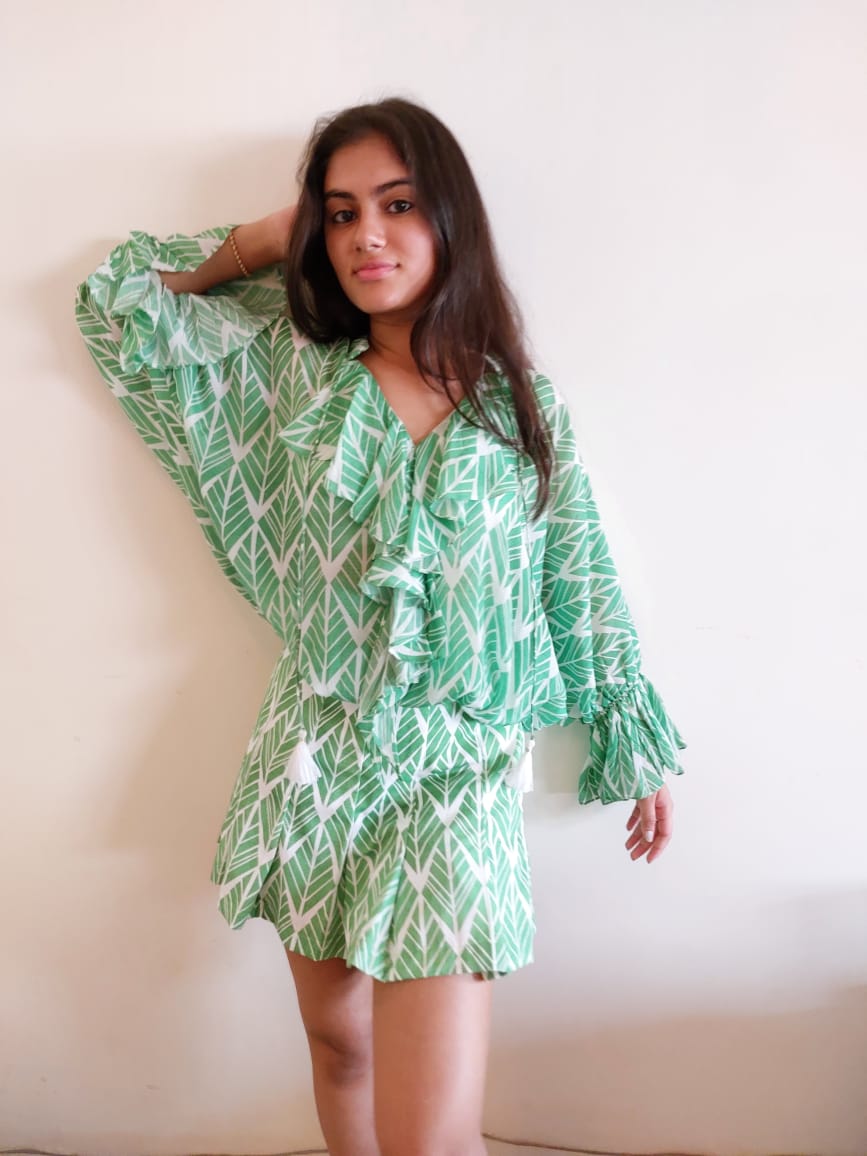 Image of Stay summery and stylish with this two-piece co-ord set featuring a white top with green leaf details and a green pleated skirt. The lightweight, breathable material promises a comfortable wear in warmer climates.  From savoirfashions.com